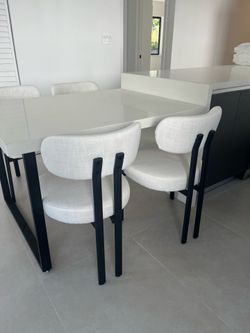 Four matching dining room chairs with black metal accents