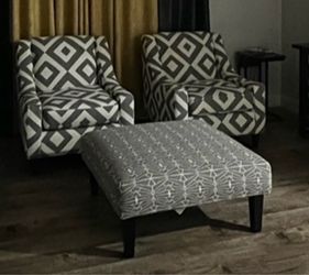 Two accent chairs with pillows, creamy sofa, ottoman