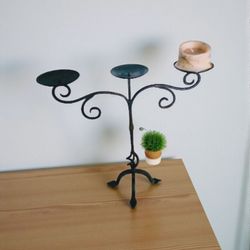 Elegant wrought iron candle holder with three arms.