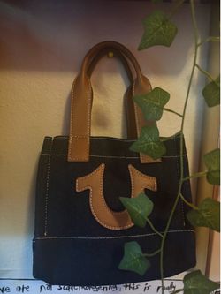 True Religion Mini Denim Tote in dark blue with tan faux leather handles and branding.