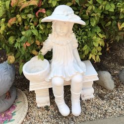 Beautiful girl with basket sitting on bench garden statue