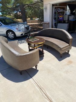 Two custom leather serpentine sofas. With custom drink service table with ice bucket.