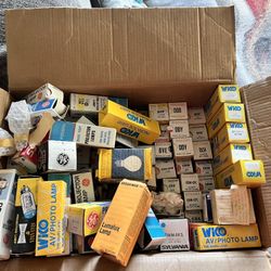 collection of vintage projector lamps and their original packaging. These are replacement lamps used in older movie and still projectors