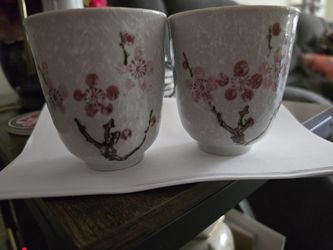 pair of ceramic tea cups featuring a textured pink Japanese Sakura (Cherry Blossom) design