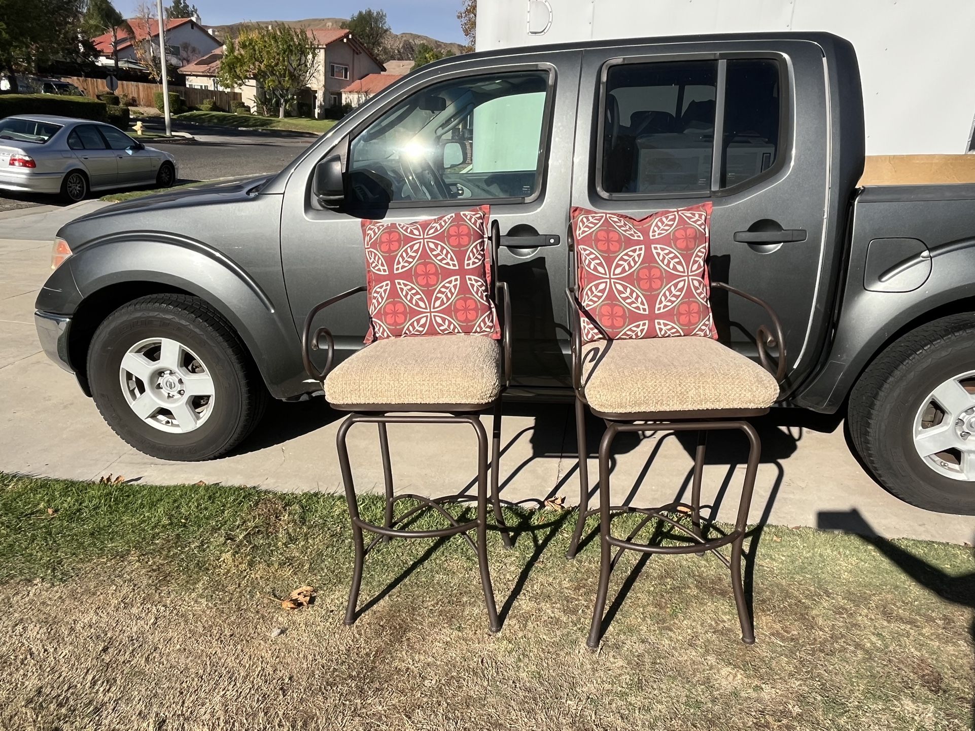 Pair Of Used Swivel Top Barstools With Cushioned Seats And Throw Pillows