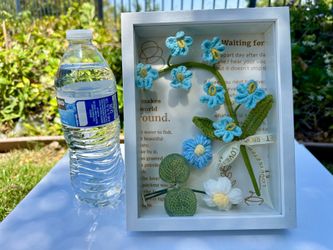 A handcrafted 3D crochet flower frame decoration featuring the message "LOVE IS ETERNAL."