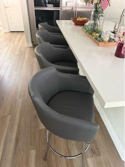 Four padded gray barstools