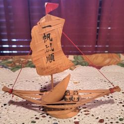 vintage handmade miniature bamboo boat, possibly from the 1970s, featuring two small Kokeshi dolls. 7"×7"