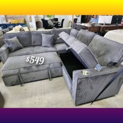 Dark gray corduroy sectional sofa with pullout bed with storage chaise cup holders included 