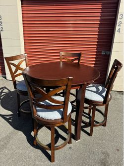 Round wooden high table and four chairs