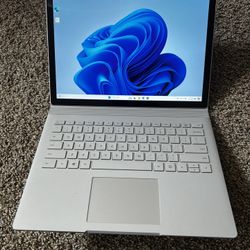 Gray Microsoft surface book 1 with keyboard and charger