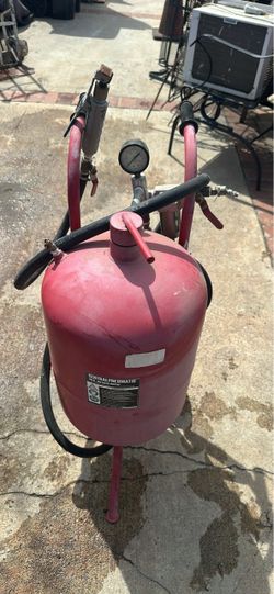 Used Central Pneumatic 40 lb. abrasive blaster with a red steel tank. This unit has a pressure gauge, moisture trap, and a 1/2 inch diameter hose. It 