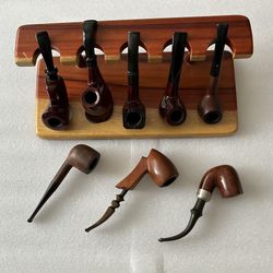 Vintage estate pipe collection with wooden wall rack.