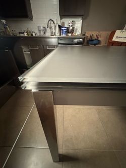 Glass and steel dining table with extending leafs