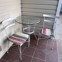 Metal chairs and table with glass table top