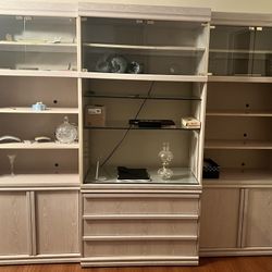 Light-colored wooden display cabinet with glass doors.