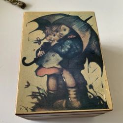Vintage Hummel Music Box Somewhere My Love Made In Japan Hummel vintage wood music box featuring a boy and girl under an umbrella. Music played is “So