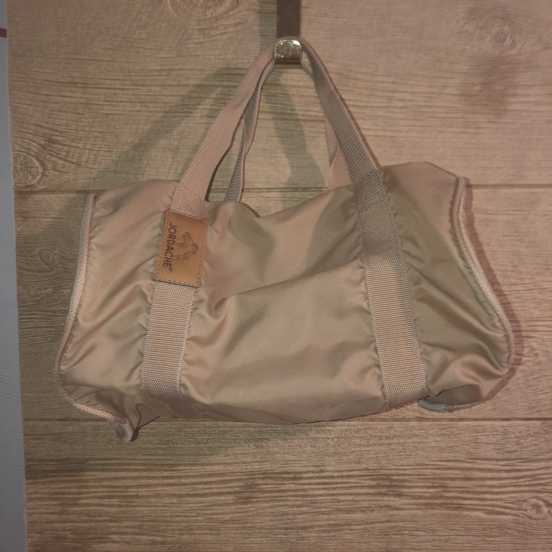 Vintage Jordache small tan duffel bag. It has a small rust spot & no shoulder strap. See pics for details and dimensions