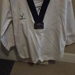 Master Shin's white V-neck Taekwondo uniform top with a black collar and a 'Vision' logo
