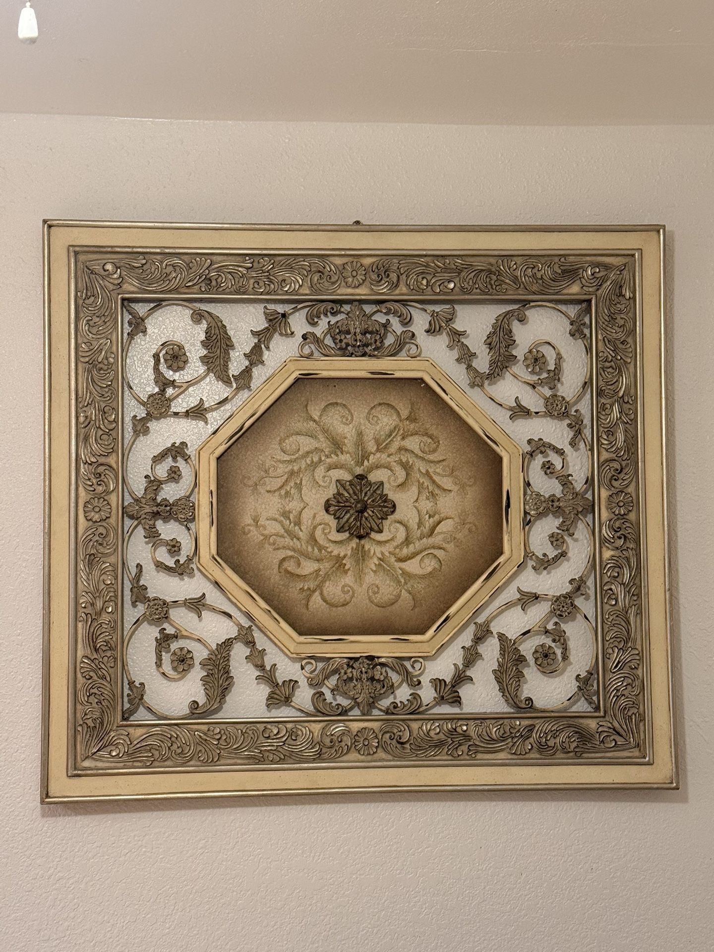 Decorative gold-toned wall piece, very detailed.