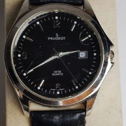 The Vintage PEUGEOT 296 WATCH is a stylish timepiece with a stainless steel back and brown leather band. Featuring a silver bezel and case, this quart