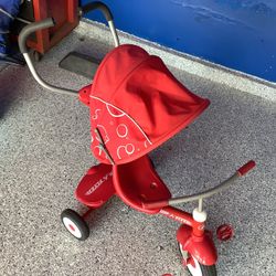 Radio Flyer push and pedal tricycle with overhead umbrella. Storage in rear