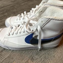 Nike Blazer Mid '77s in white with a blue swoosh.