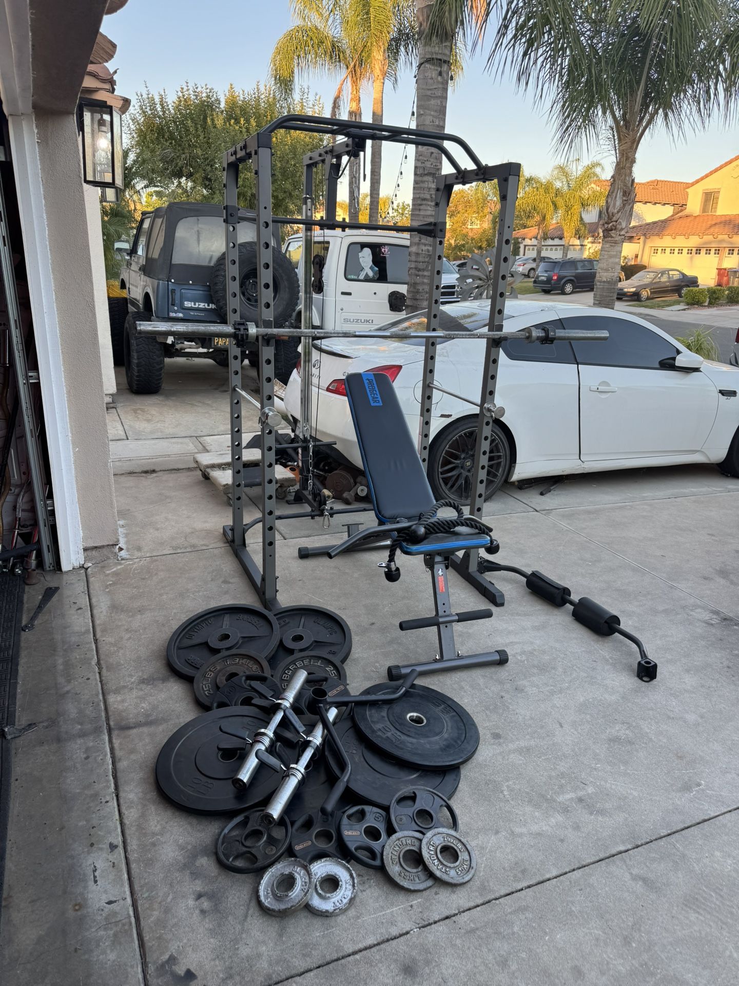 Bench press/squat rack with pulley systems and 7ft bar plus 230lbs of Olympic weights and adjustable dumbbells