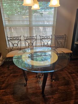 Wrought Iron Table with 4 chairsDecorative metal table with intricate scrollwork design. 

Glass Diameter 44"
Table Height 30"
Chair floor to seat is 