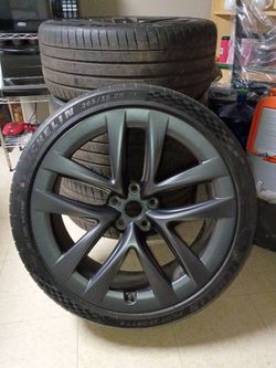These are Tesla Überturbine wheels (commonly found on the Tesla Model Y Performance).
​Rim Name: Tesla OEM Überturbine (Satin/Matte Dark Gray finish)
