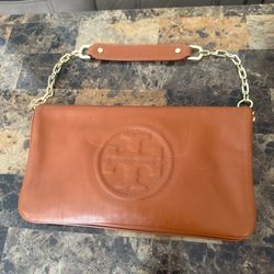 Authentic Tory Burch leather clutch in a beautiful caramel/cognac color. Features an elegant embossed logo on the front with clean stitching and high-
