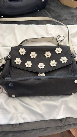 This black leather Michael Kors Bristol crossbody is adorned with white flower metal studs.