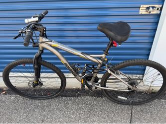 Mongoose Ledge 3.1 is a full-suspension mountain bike featuring a lightweight aluminum frame, 29-inch wheels, and a front suspension fork paired with 