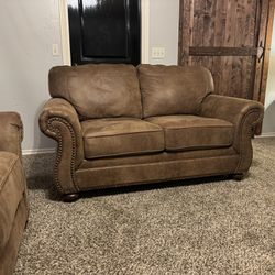 Signature Design by Ashley Larkinhurst Faux Leather Sofa with Nailhead Trim and 2 Accent Pillows, Brown