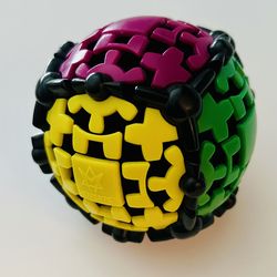The Meffert's Gear Ball is a spherical puzzle with interconnecting gears that rotates, allowing you to solve it by aligning all six faces with a singl