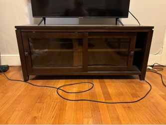 Dark wood TV stand with sliding glass doors