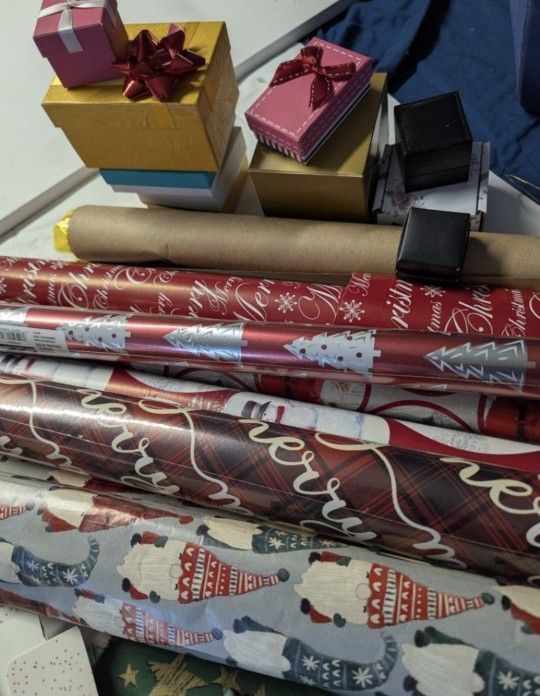 Christmas wrapping paper some new in the roll with plastic others opened.
A box of bows
Gift bags, gift boxes and ribbon