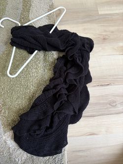 Black knit infinity scarf features layered ruffles. New without tags.