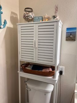 Behind toilet cabinet