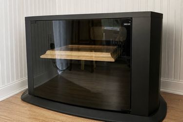 Black TV stand/ cabinet with a smoked glass door