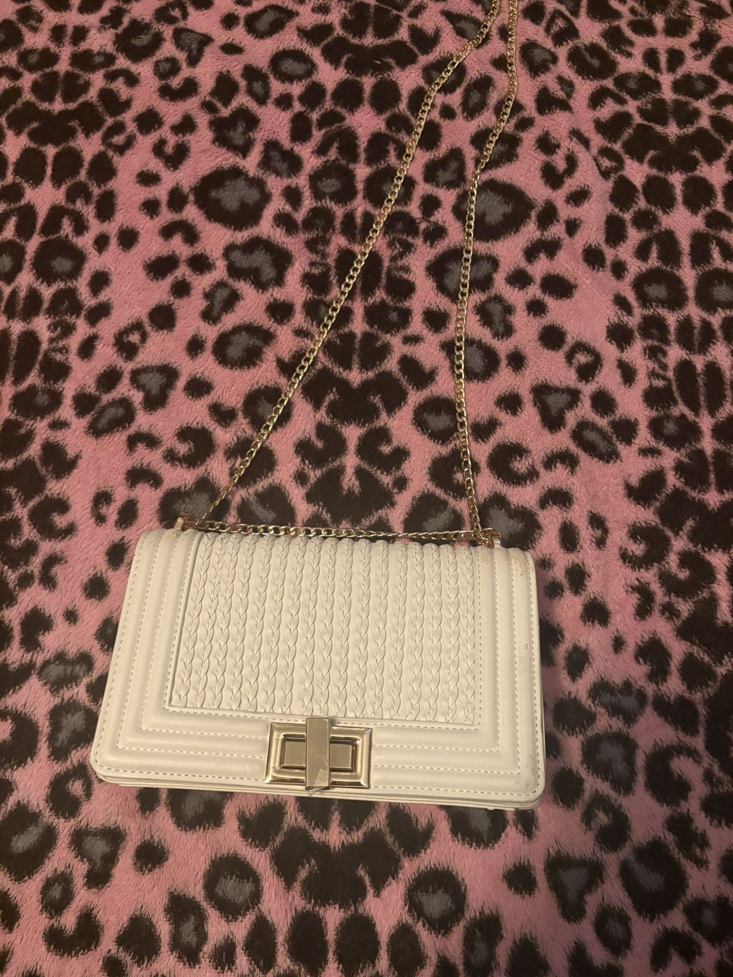 white bag with gold shoulder strap