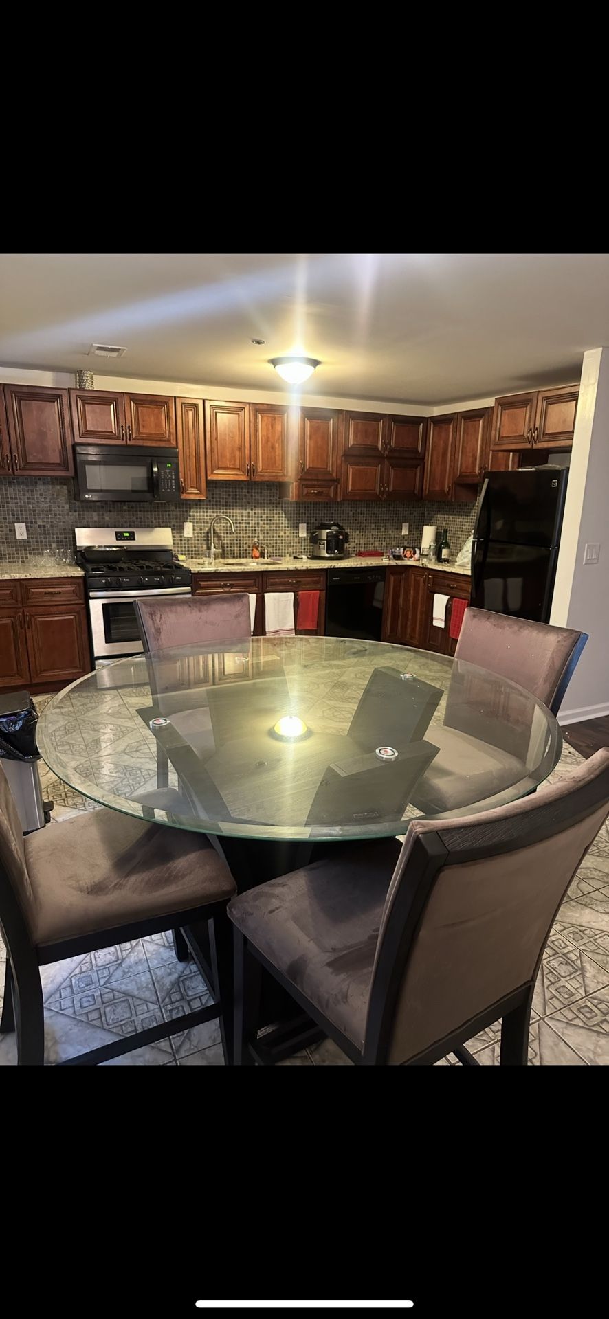 Elegant brown dining table with a sleek glass top and four matching wooden chair