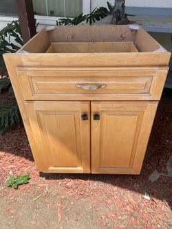 Wood base cabinet is designed with two doors and interior pull-out shelving.