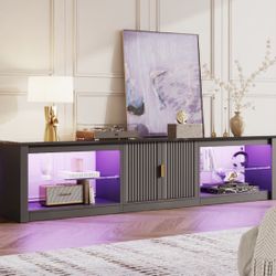 80" Fluted Glossy Black TV Stand for TVs up to 85" with LED lighting, cabinet, and adjustable shelf