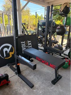 Rogue squat stand 3x3 with j hooks safety bars and a flat rogue bench with Thompson fat pad all in like new condition