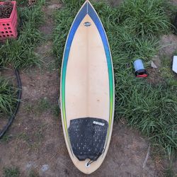 Ford branded surfboard featuring a thruster fin setup (three fins).