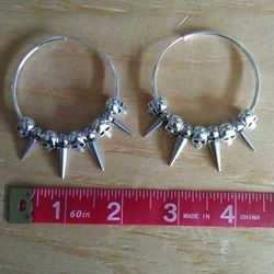 Silver spike hoop earrings with skulls