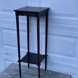 Vintage 1999 Bombay Company mahogany wood 2-tier plant stand in fair condition. Top and shelf show water bubbles and wear as shown. Measures 35.5” tal