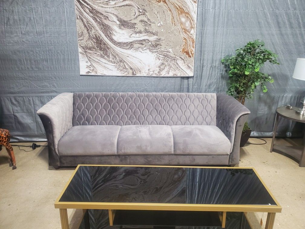 Gray Velvet Sofa With A Design On Back