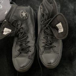 black high-top shoes are Converse Chuck Taylor